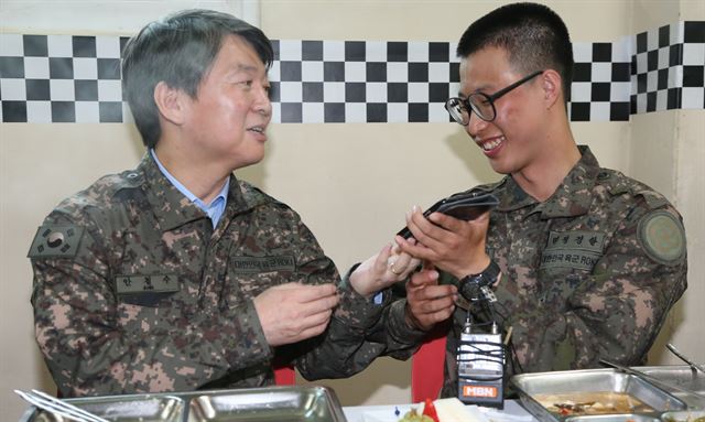 안철수 국민의당 상임 공동대표가 12일 경기도 연천 28사단 내 병영식당에서 식사 도중 한 병사의 어머니와 통화한 뒤 전화를 바꿔주고 있다. 국회사진기자단