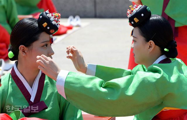 16일 오전 서울 중구 남산한옥마을에서 열린 '44회 성년의날 기념 전통성년식 재현행사'에서 1997년생 참석자들이 서로 옷 매무새를 고쳐주고 있다. 서재훈기자