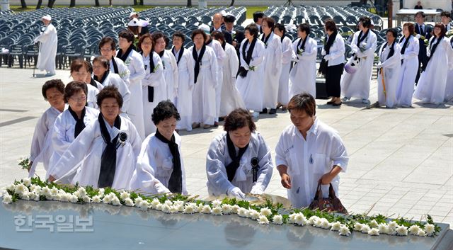 5·18 민주화운동 36주년을 하루 앞둔 17일 광주 북구 운정동 국립 5·18 민주묘지에서 5월 유가족들이 헌화를 하고 있다. 서재훈기자