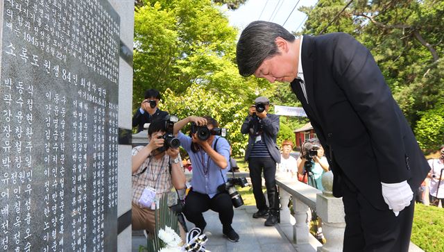 안철수 국민의당 상임 공동대표가 18일 오후 전남 고흥군 국립소록도병원을 방문해 해방 직후 희생당한 한센인들을 기리는 추모비에 헌화한 뒤 묵념하고 있다. 고흥=연합뉴스