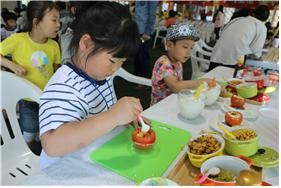 16일 전남 장성에서 열린 토마토의 날에 참가한 어린들이 토마토를 이용해 샐러드를 만들고 있다. /2016-05-19(한국일보)