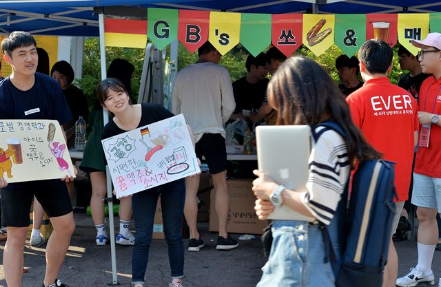 축제가 한창인 19일 서울 종로구 상명대학교에서 한 학생이 주점을 홍보하는 학생들을 외면한 채 걸어가고 있다. 신재훈 인턴기자 (세종대 광전자공학과 4)