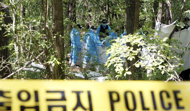 20일 경북 군위군 고로면과 영천시 화북면 경계지역 지방도 옆 야산 골짜기에서 대구 건설사 사장 김모(48)씨의 시신을 발견한 경찰이 현장을 감식하고 있다. 연합