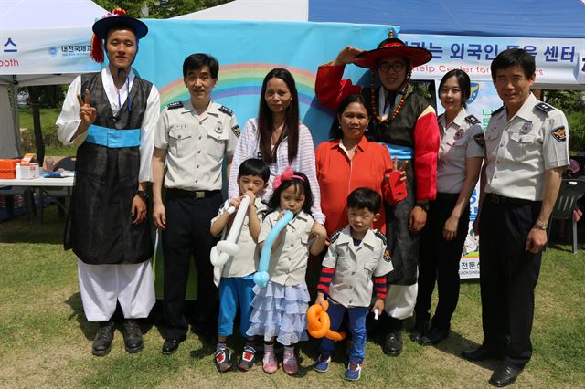 대전둔산경찰서 직원들이 21일 대전 보라매공원에서 열린 '제8회 세계인어울림 한마당 축제'장에 설치한 경찰 홍보센터 앞에서 방문한 외국인 가족과 기념촬영을 하고 있다. 대전둔산경찰서 제공