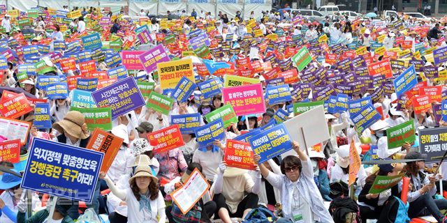 한국어린이집총연합회 회원 1만 5000여명이 23일 오후서울광장에서 열린 '맞춤형보육제도 개선 및 시행연기 촉구대회' 에서 맞춤형 보육 강행 중단 촉구, 영아들 차별대우 반대, 보험료 현실화 등의 내용이 적힌 피켓을 들고 구호를 외치고 있다. 신상순 선임기자ssshin@hankookilbo.com