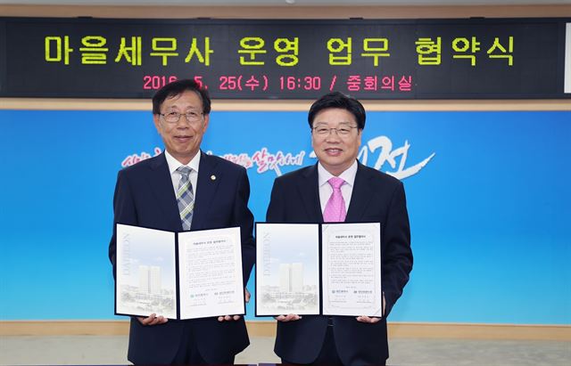 권선택(오른쪽) 대전시장이 25일 유병섭 대전지방세무사회장과 마을세무사 운영 업무협약식을 체결한 후 협약서를 들어 보이고 있다. 대전시제공