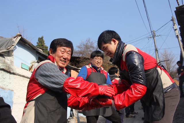 김치현(왼쪽) 롯데건설 대표이사가 임직원과 함께 ‘사랑의 연탄나눔’ 봉사활동을 하고 있다. 롯데건설 제공