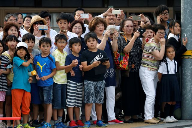 버락 오바마 미 대통령이 27일 원자폭탄을 투하한지 71년만에 미 현직 대통령으로는 처음으로 히로시마를 방문한 가운데 많은 시민들이 오바마 대통령을 태운 차량을 바라보고 있다. 로이터 뉴스1