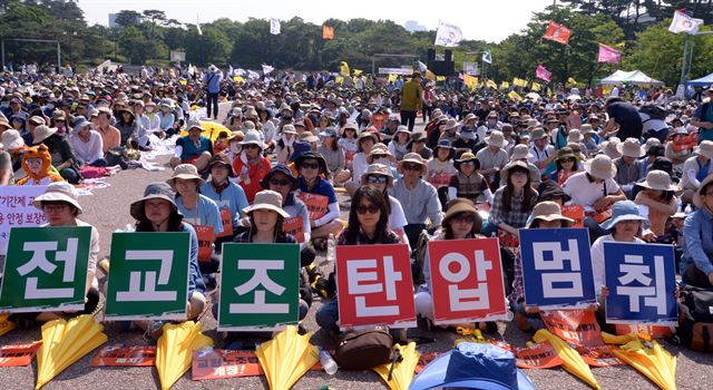 전교조 조합원들이 28일 오후 서울 영등포구 여의도공원 문화마당에서 열린 전교조 결성 27주년 기념 전국교사대회에서 ‘전교조 탄압 멈춰’라고 적힌 피켓을 들고 있다. 뉴시스