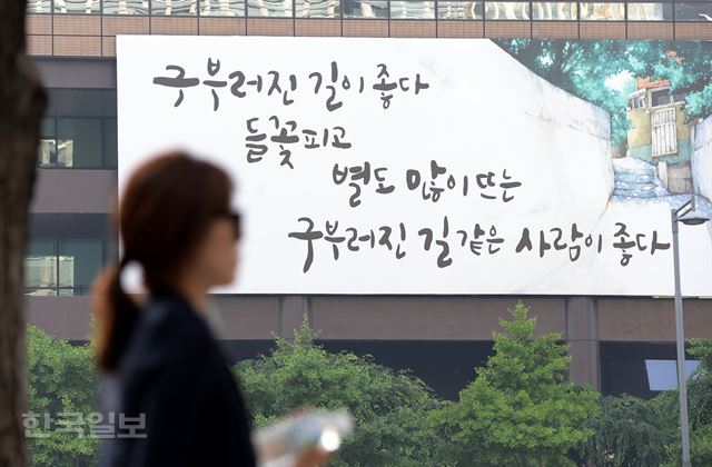 30일 서울 세종로 교보생명 외벽에 걸린 광화문글판이 여름을 맞아 이준관 시인의 '구부러진 길'에서 "구부러진 길이 좋다 들꽃 피고 별도 많이 뜨는 구부러진 길 같은 사람이 좋다" 는 글귀를 걸었다. 광화문글판은 지난 1991년부터 26년째 거리를 오가는 이들에게 희망과 사랑의 메시지를 전해오고 있다. 광화문글판 '여름편'은 오는 8월 말까지 광화문 교보생명빌딩과 강남 교보타워 등에 걸린다. 홍인기 기자 hongik@hankookilbo.com