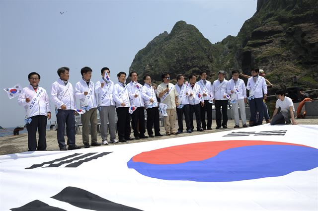 경북의 시장ㆍ군수들이 31일 독도에서 독도수호결의대회를 열고 대형 태극기 앞에서 독도 홍보대사 가수 정광태와 함께 '독도는 우리 땅'을 열창하며 독도수호의지를 다지고 있다. 울릉군 제공