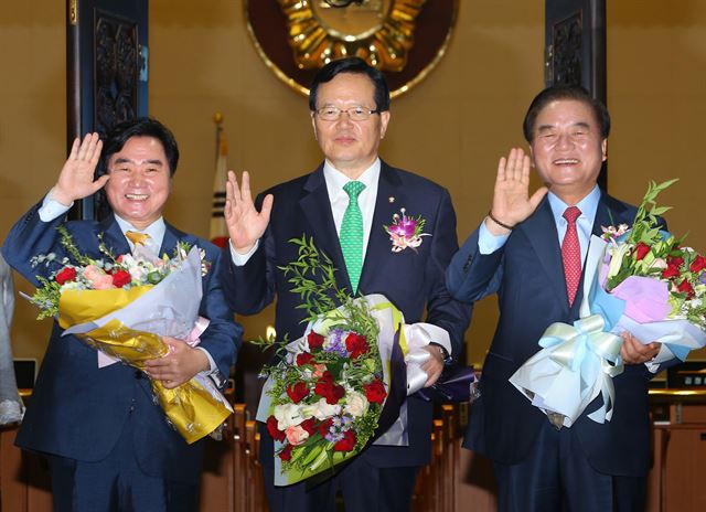 정의화 국회의장과 정갑윤, 이석현 국회부의장이 27일 오전 국회 로텐더홀에서 열린 제68주년 국회 개원 기념식 후 본 회의장을 돌아본 뒤 퇴임 축하 꽃다발을 들고 기념촬영을 하고 있다. 연합뉴스