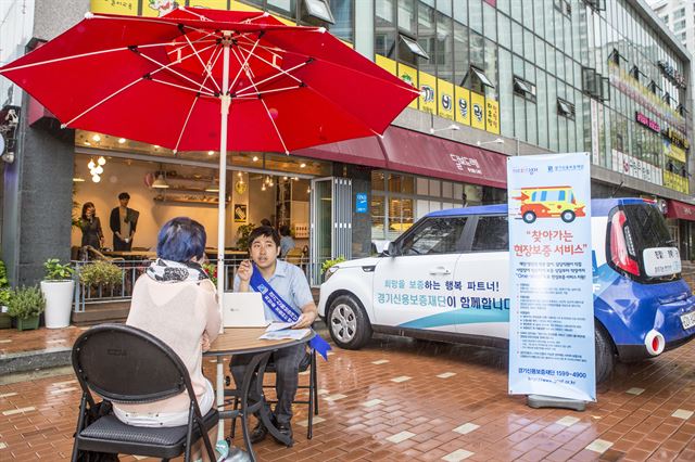 경기신용보증재단 직원이 직접 안양 상가를 방문해 보증서비스를 해주고 있다. 경기신보 제공