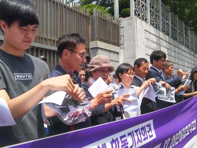 기자회견에 참가한 부산지역 시민단체 대표들이 10억엔과 아베 일본 총리 사진이 인쇄된 종이를 구기는 퍼포먼스를 진행하고 있다.