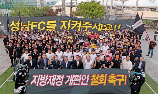 성남FC 선수단과 프런트 직원들이 지난달 31일 성남 탄천종합운동장 광장에서 팬들과 지방재정개편안 철회 촉구 설명회를 진행한 뒤 기념사진을 찍고 있다. 성남FC구단 제공