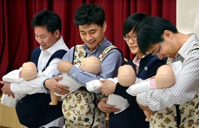 지난 4월 서울 양재동 서초구청에서 열린 임산부 체험교실에서 예비 아빠들이 아기 돌보기 실습을 받고 있다. 한국일보 자료사진