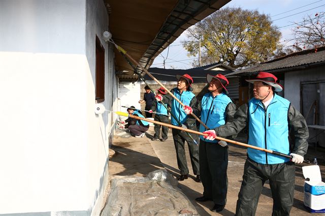 전남 나주시 남평읍의 한 농가에서 지낞 11월 진행된 농어촌 집 고쳐주기 봉사활동에 나선 농어천공사 직원들이 외벽에 페인트칠을 하고 있다. 농어촌공사 제공