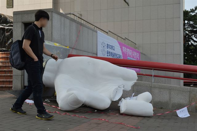 지난 1일 서울 홍익대학교 정문 앞에 설치된 극우성향 사이트 '일간베스트저장소'(일베)를 상징하는 손 모양의 동상이 파손된 모습 옆으로 학생들이 등교하고 있다. 신재훈 인턴기자 (세종대 광전자공학과 4)