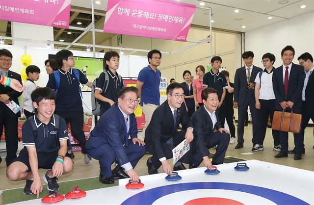 권영진(앞줄 오른쪽에서 첫번째) 대구시장과 우동기(3번째) 대구시교육감이 지난 16일 제2회 대한민국 어울림축제가 열린 대구 엑스코에서 장애인 컬링을 체험하고 있다. 대구시교육청 제공