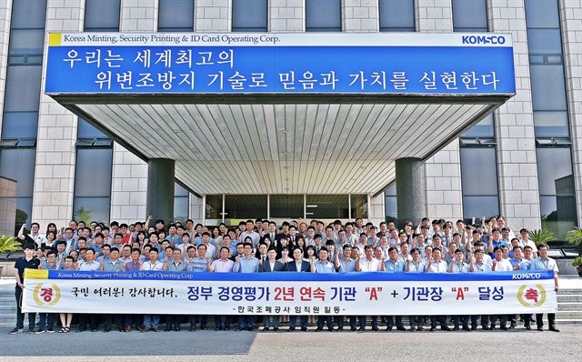 한국조폐공사 김화동 사장과 임직원들이 경영평가 A등급과 기관장 평가에서 우수등급을 받은 것을 기념하는 사진을 찍으며 기뻐하고 있다. 한국조폐공사 제공