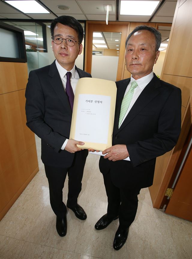 23일 오후 서울 중구 남대문로 한진빌딩에서 진행된 박태환 선수 측 입장표명 기자회견에서 법무법인 광장의 임성우(왼쪽) 변호사와 박태환의 아버지인 박인호씨가 가처분 신청서를 들어보이고 있다. 박태환 측은 이날 박태환의 2016 리우올림픽 출전을 위한 권리 구제를 위해 서울동부지방법원에 가처분 신청을 제출한다고 밝혔다. 연합뉴스