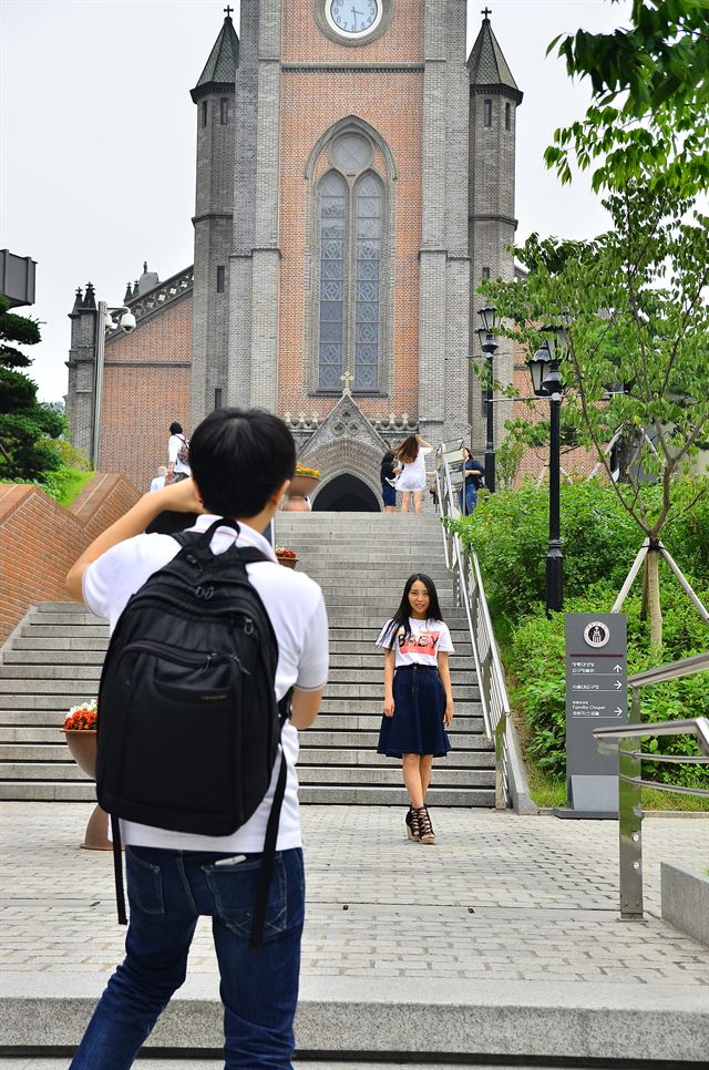 젊은 남녀가 성당으로 올라가는 계단에서 사진을 찍고 있다. 명동성당을 배경으로 사진 촬영을 하는 젊은이들이 부쩍 늘었다.