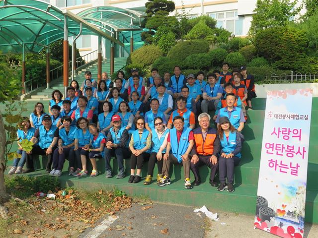 대전지방보훈청과 대전봉사체험교실 회원들이 26일 동구 삼성동 국가유공자 이상호씨 가정에 '사랑의 연탄'을 전달하기 앞서 게룡공고에 집결해 기념촬영을 했다. 대전봉사체험교실 제공 /2016-06-26(한국일보)