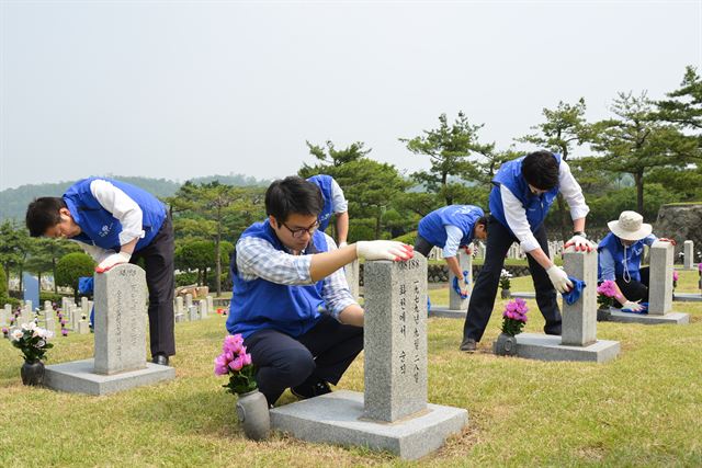 지난달 호국보훈의 달을 맞아 효성 임직원들이 국립서울현충원에서 묘비를 닦는 등 묘역 정화 활동을 진행하고 있다. 효성 제공