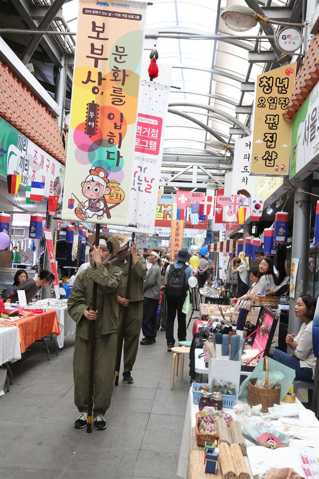 충남 예덕상무사와 저산팔읍 보부상단이 29일 부여 중앙시장을 한 바퀴 도는 길놀이를 하고 있다. 충남도 제공/2016-06-30(한국일보)