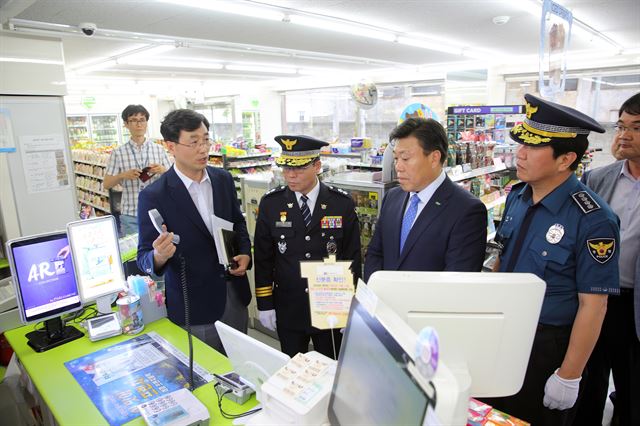 충북경찰청 관계자들이 30일 충북 청주시 청원구의 한 반딧불 편의점에서 수화기만 들면 자동으로 112신고가 되는 무다이얼링 시스템을 시연하고 있다. 충북경찰청 제공