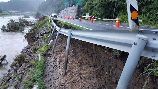 충북 옥천군 군서면 월전리 앞 19호 군도가 갑자기 불어난 하천물에 석축이 무너지는 바람에 위험스럽게 붕 떠 있다. 옥천군 제공