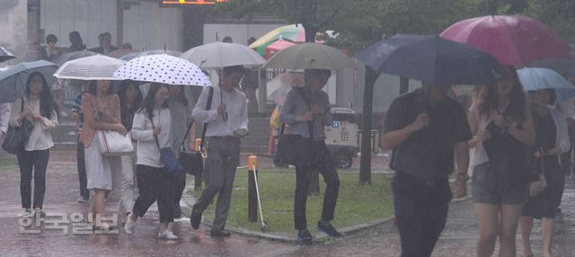 [저작권 한국일보]서울지역에 호우경보가 내려진 5일 오전 서울 여의도역에서 시민들이 출근길 발걸음을 옮기고 있다./배우한기자 bwh3140@hankookilbo.com