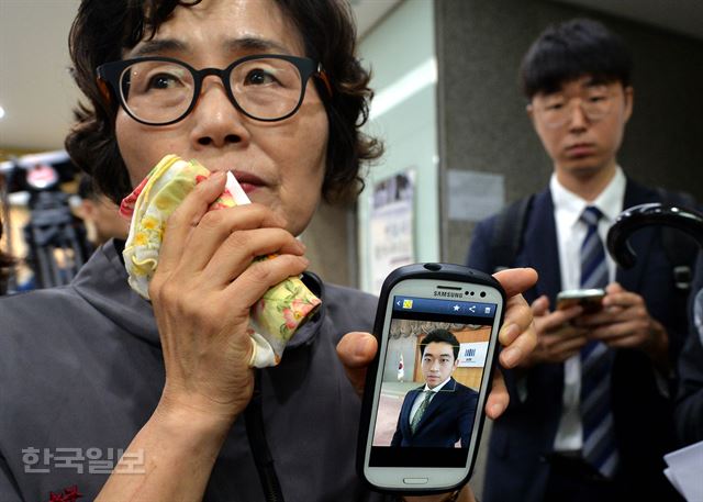 5일 오후 서울지방변호사협회에서 사법연수원 41기 동기회 주최로 열린 '김홍영 검사의 죽음에 관한 진상규명과 책임자 처벌 촉구 기자회견'에서 김 검사의 어머니 이기남 씨가 임용 당시의 사진을 공개하고 있다. 서재훈기자 spring@hankookilbo.com