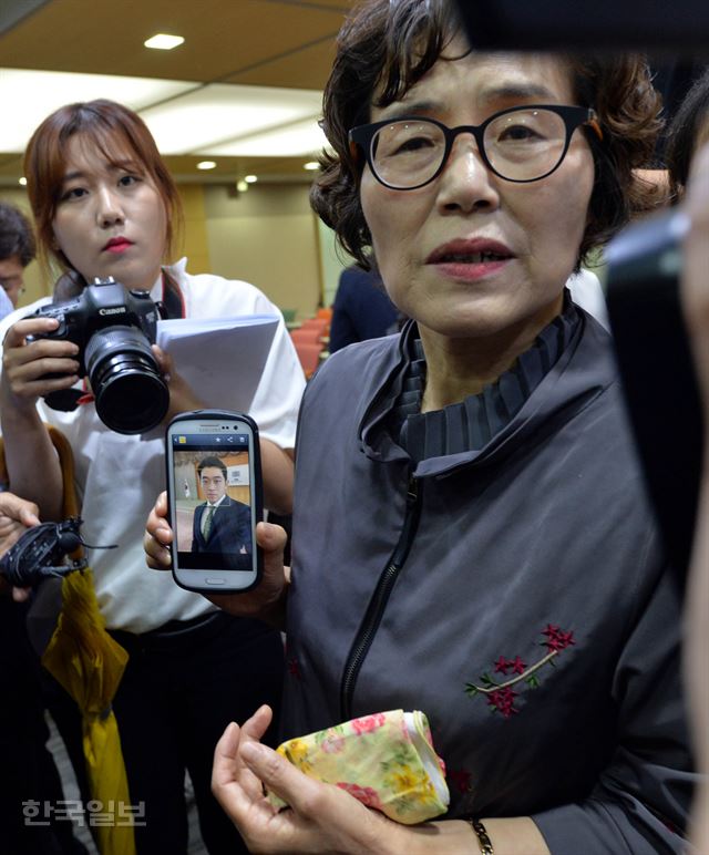 5일 오후 서울지방변호사협회에서 사법연수원 41기 동기회 주최로 열린 '김홍영 검사의 죽음에 관한 진상규명과 책임자 처벌을 촉구하는 기자회견'에서 김 검사의 어머니 이기남 씨가 임용 당시의 김검사 사진을 보여주고 있다. 서재훈기자 spring@hankookilbo.com