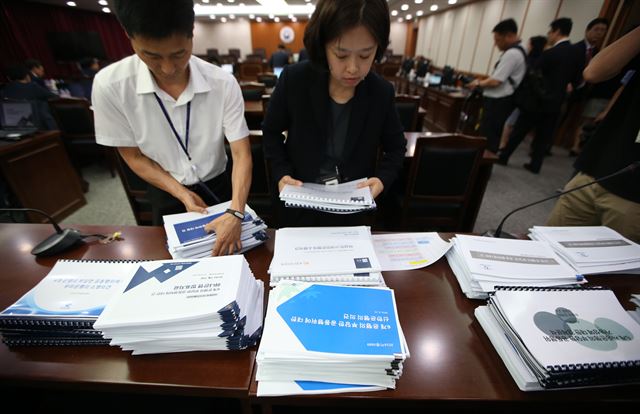 지난달 22일 국민·농협·신한·우리·하나·SC은행 등 6개 은행의 CD금리 담합 사건에 대한 1차 전원회의 심의에서 공정위 관계자들이 은행 측 소명자료를 정리하고 있다. 연합뉴스