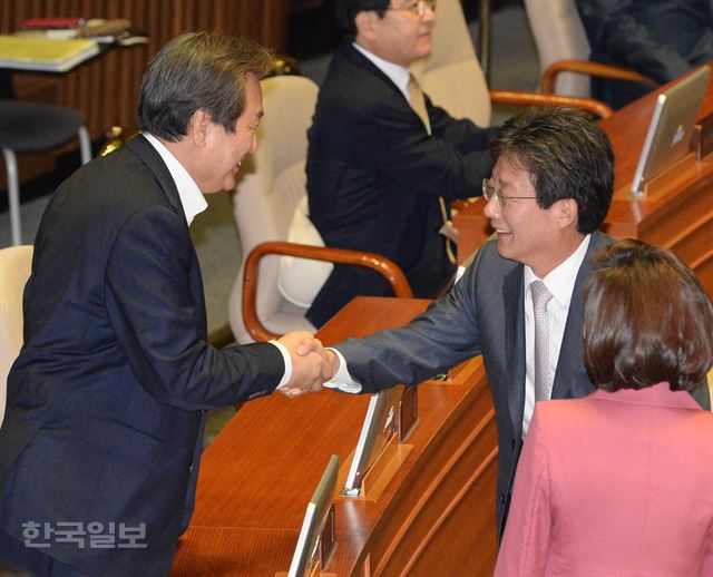 지난달 20일 국회 본회의장에서 김무성(왼쪽) 전 새누리당 대표가 복당한 유승민 의원과 악수를 나누며 인사하고 있다. 한국일보 자료사진.