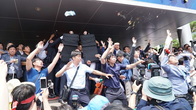 15일 오전 경북 성주군 성주군청 현관에서 황교안 총리 경호원과 경찰관들이 성난 주민들이 던지는 물병과 계란을 방탄복과 손바닥 등으로 막고 있다. 김정혜기자 kjh@hankookilbo.com