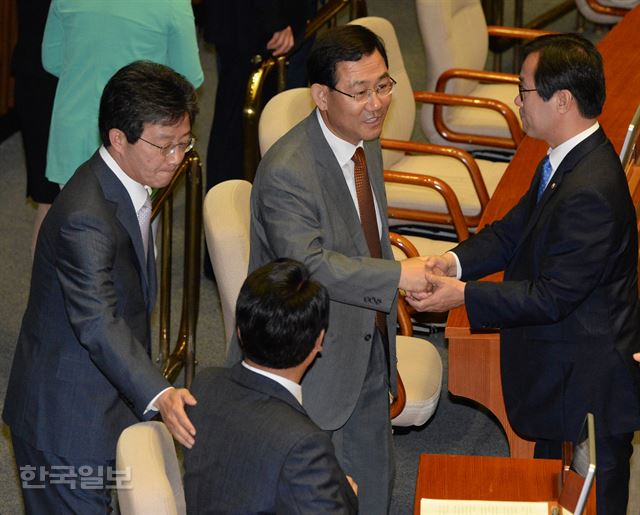 지난달 20일 국회 본회의장에서 복당을 앞둔 주호영(가운데) 의원이 김영우 새누리당 의원과 악수를 나누고 있다. 유승민(왼쪽) 의원은 정진석 원내대표와 이야기를 나누고 있다. 오대근 기자 inliner@hankookilbo.com