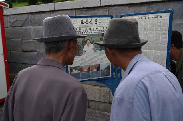 북한 주민들이 20일 평양 거리에서 스커드와 노동 미사일로 추정되는 탄도미사일 시험발사 관련 사진을 게재한 노동신문을 읽고 있다. 1면에 실린 8장의 사진에는 대형 한반도 지도가 펼쳐져있는 탁자 앞에 김정은 노동당 위원장이 앉아있는 모습, 스커드 미사일과 노동미사일이 불꽃을 내뿜으며 발사되는 장면 등이 담겨있다. 특히 '전략군화력타격계획'이라는 제목이 붙은 탁자 위의 대형 한반도 지도에는 북한의 황주 일대에서 동해상으로 날아가는 비행궤적이 표시돼 있으며, 특히 동해상 낙하지점에서는 부산·울산 주변 지역까지 곡선이 그려져 있고 탄착지점도 표시했다. AFP 연합뉴스