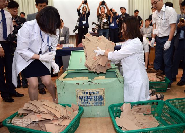 [저작권 한국일보] 30년간 열지 못했던 1987년 12월 제13대 대통령선거 구로구을 부재자 투표함이 21일 오전 서울 종로구 선거연수원 대강당에서 개봉되어 선관위 직원들이 투표용지를 꺼내고 있다. 1987년 대통령 선거 당시 구로구청 농성사건의 발단이 됐던 투표함은 중앙 선관위 수장고에 보관되어 오다 한국정치학회의 연구용역 요청에 따라 개봉됐다.2016.7.21 신상순 선임기자ssshin@hankookilbo.com /2016-07-21(한국