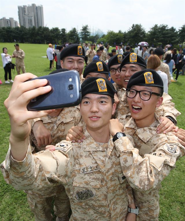 지난 19일 서울 송파구 특수전사령부에서 열린 아크부대 11진 환송식에서 파병 장병들이 동료들과 함께 휴대폰으로 사진을 찍고 있다. 연합뉴스