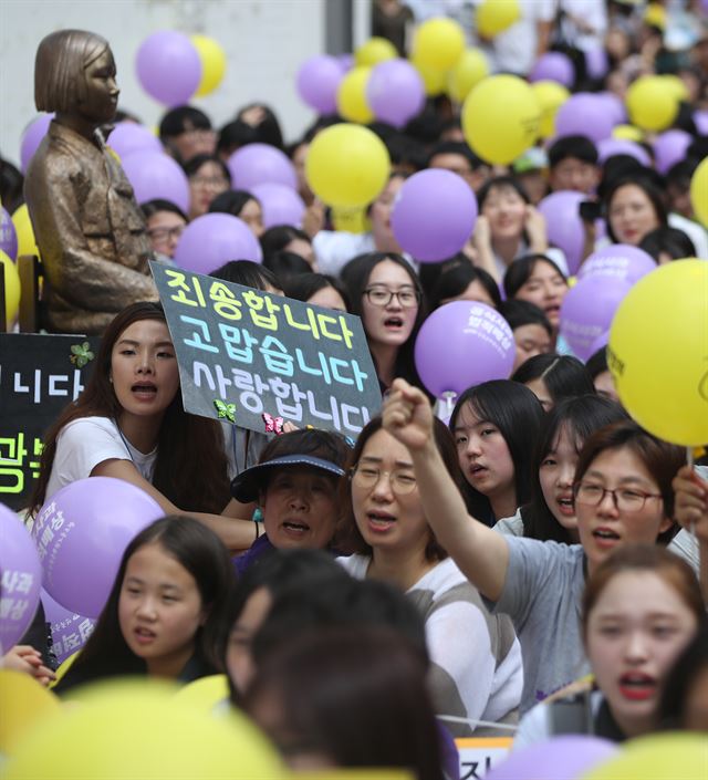 27일 오후 서울 종로구 옛 일본대사관 앞에서 열린 일본군 위안부 문제 해결을 위한 수요집회에서 참가자들이 일본 정부의 사죄 등을 촉구하며 구호를 외치고 있다. 연합뉴스