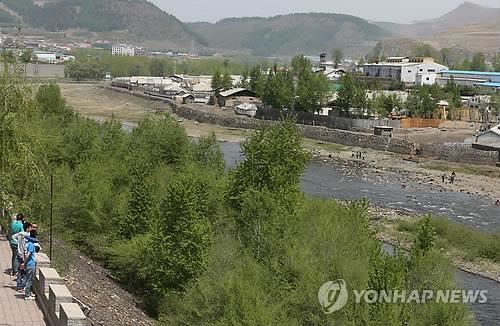 중국 지린성 칭바이현에서 관광객들이 강 건너 북한 혜산시를 바라보는 모습. 연합뉴스