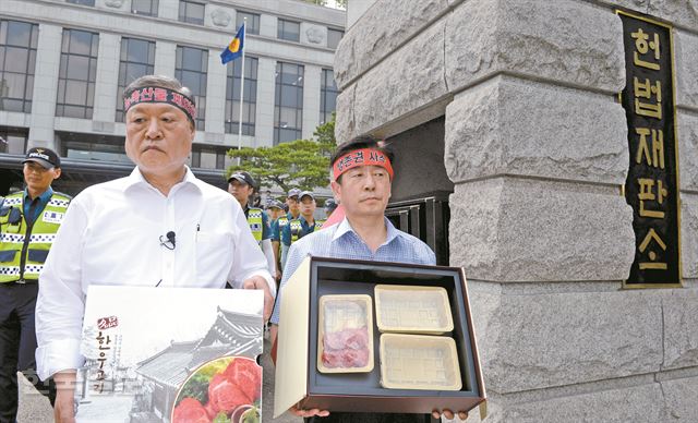 '부정청탁 및 금품 등 수수의 금지에 관한 법률'(김영란법)에 대한 헌법소원심판 사건 선고가 열린 28일 오후 서울 종로구 헌법재판소 정문 앞에서 농민들이 한우 선물세트를 들고 합헌에 반대하는 시위를 하고 있다. 신상순 선임기자ssshin@hankookilbo.com