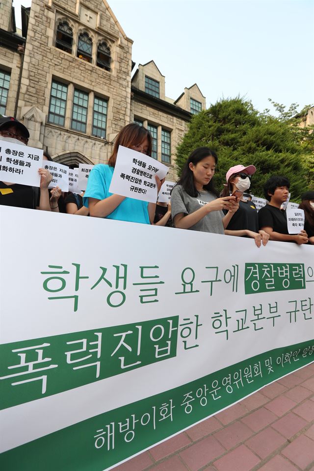 서울 서대문구 이화여자대학교 본관 앞에 모인 재학생들이 30일 낮 12시쯤 경찰이 교내에 진입해 농성하는 학생들을 진압한 것을 규탄하는 기자회견을 하고 있다. 연합뉴스