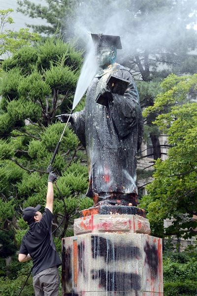 31일 서울 서대문구 이화여자대학교 본관 앞에서 학생들에 의해 훼손된 초대총장 김활란 박사 동상을 직원들이 세척하고 있다.왕태석기자 kingwang@hankookilbo.com