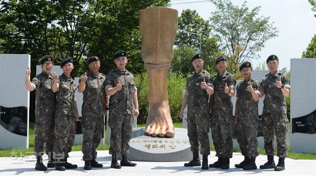 4일 경기 파주시 임진각에서 열린 북한 비무장지대(DMZ) 지뢰도발 1주기 기념행사에서 당시 작전에 참여했던 수색대 전우 8인이 ‘평화의 발’ 조형물 앞에서 구호를 외치고 있다. 왼쪽부터 박준호 예비역 병장, 이형민 하사, 박선일 원사, 하재헌 하사, 김정원 하사, 정교성 중사, 최유성 예비역 병장, 문시준 중위. 서재훈기자 spring@hankookilbo.com