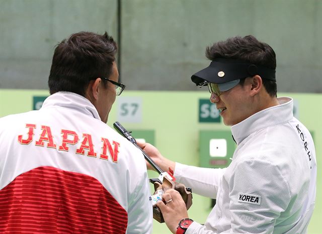 리우데자네이루 올림픽을 하루 앞둔 4일 오후(현지시간) 대한민국 사격 대표팀 진종오 선수가 올림픽 슈팅센터에서 일본 선수의 총을 만져 보고 있다./2016.8.4/리우데자네이루=올림픽사진공동취재단