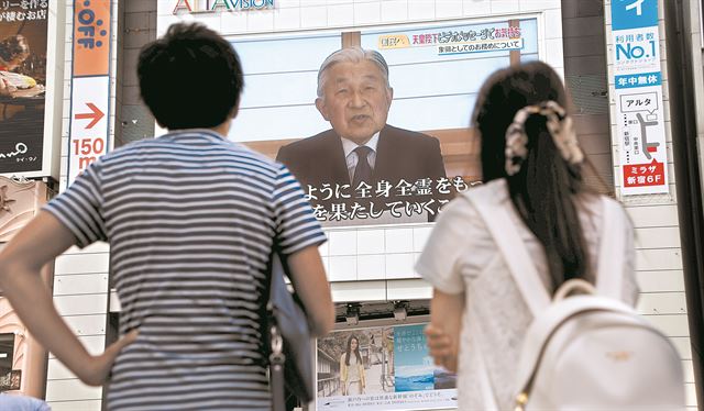 일본 도쿄 시민들이 8일 가던 길을 멈추고 도쿄 시내 건물에 설치된 대형 스크린에서 흘러 나오는 아키히토 일왕의 양위 메시지에 이목을 집중하고 있다. 도쿄=로이터 연합뉴스