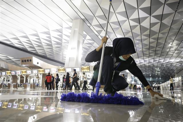 인도네시아 자카르타의 스카르노 하타 공항에서 9일(현지시간) 국제공항 제3터미널 개장 첫날을 맞은 가운데 한 공항 근로자가 바닥 청소를 하고 있다. EPA 연합뉴스